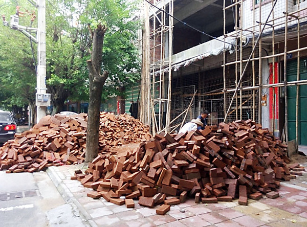 建設路建筑材料亂堆放，人行道變“攔路虎”